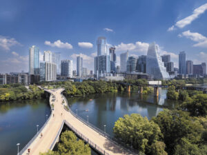 Downtown Austin skyline with trail bridge crossing river with blue sky