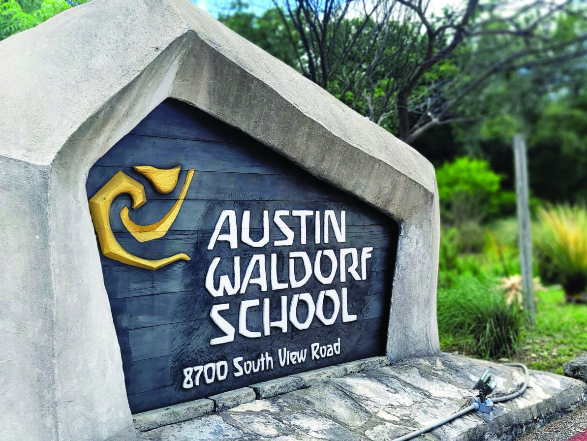 Austin Waldorf school sign with logo on stone and wood at entrance