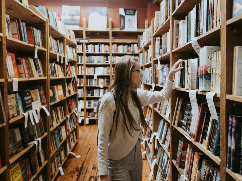 girl browses books in a school library for article Top 20 Public Schools in the Austin Area for newcomers moving to Austin.