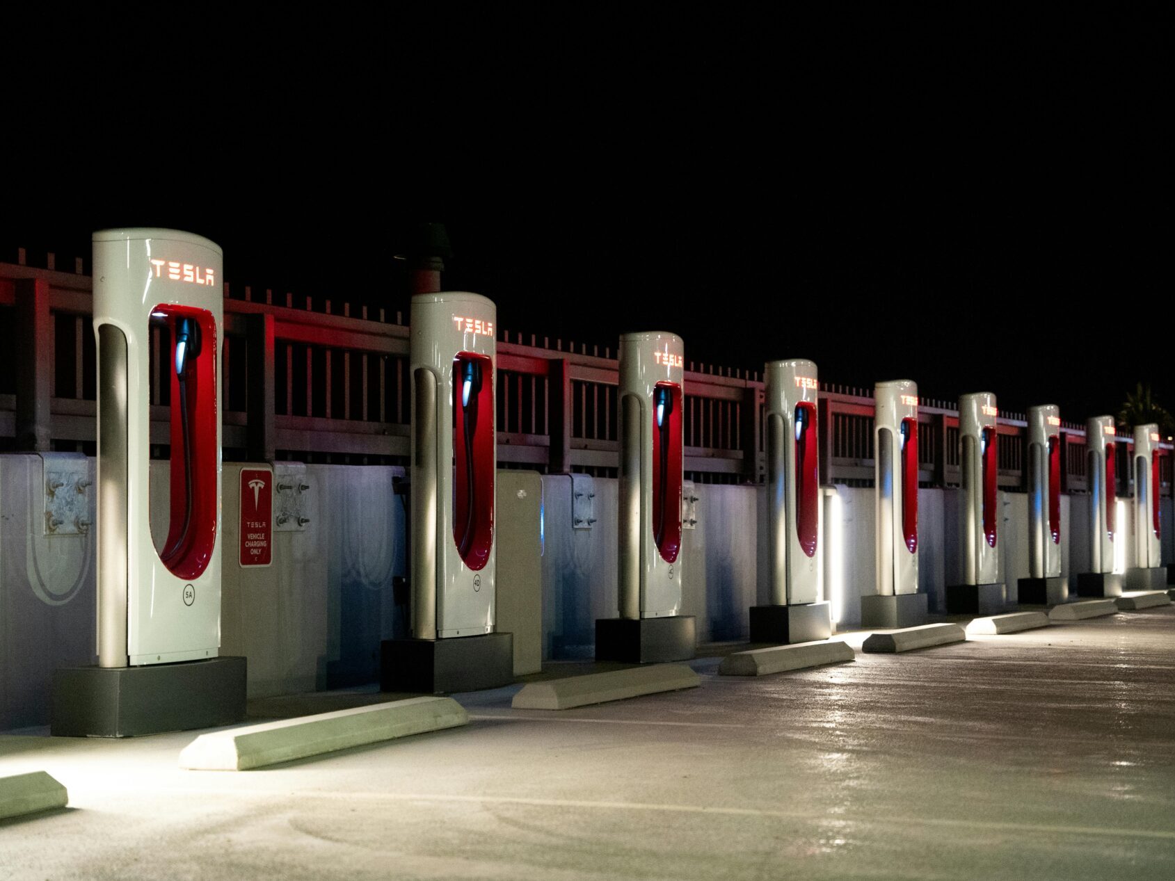 row of tesla charging stations at night