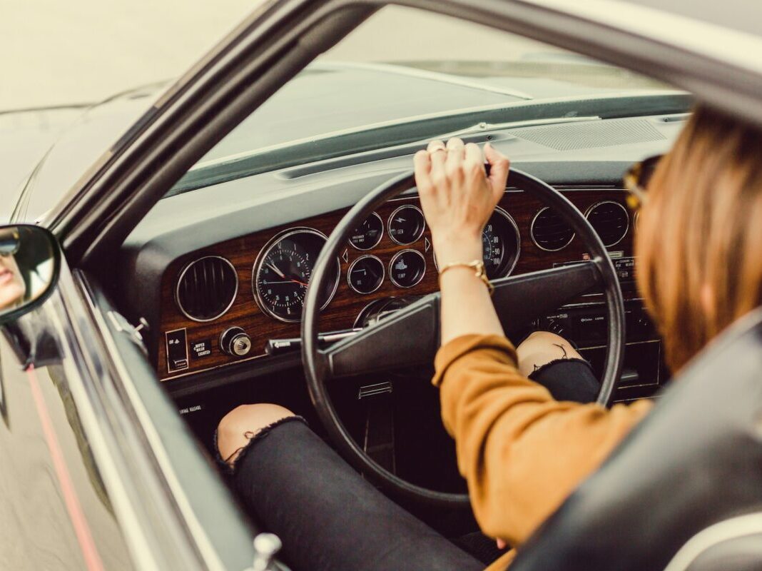 a woman holding the steering wheel while driving her car