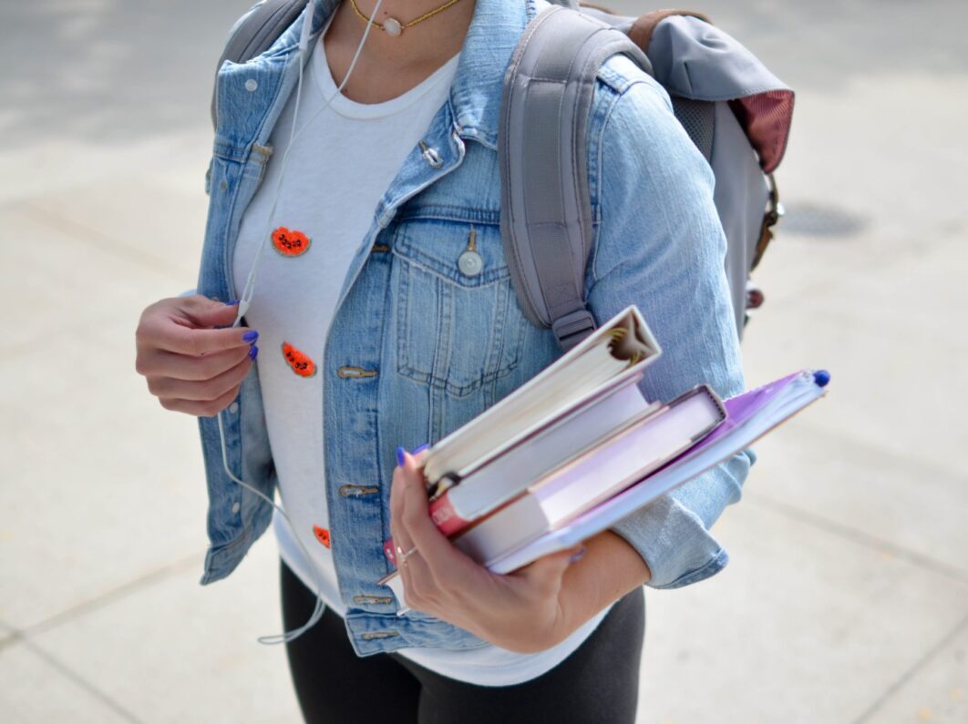 A woman attending school holding her books