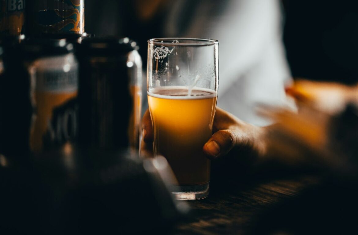 a glass of beer in a man's hand