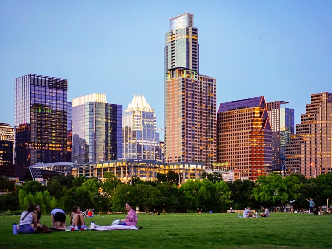 Austin buildings with people out on the lawn sitting
