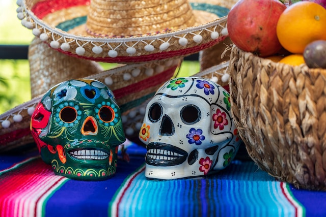 Two skulls on a table painted to resemble The Day of The Dead.