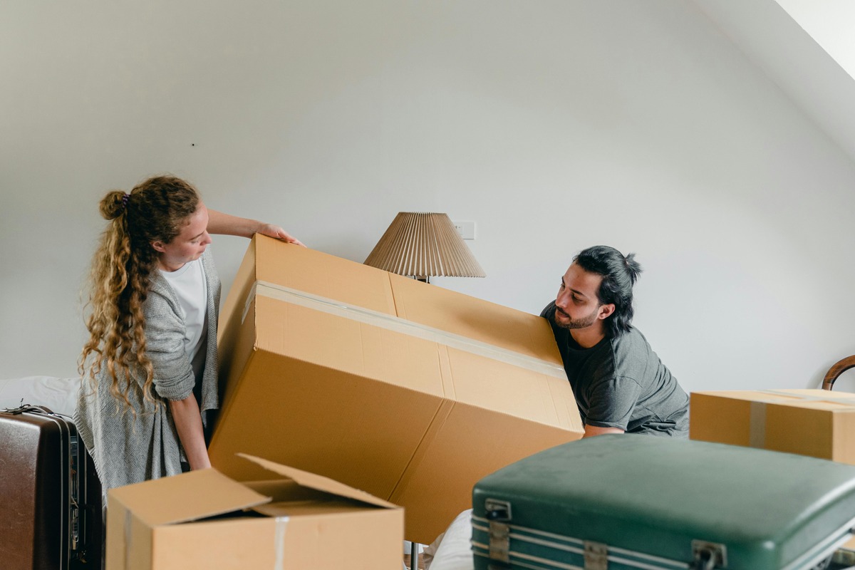 man and woman moving a box together on moving day