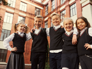 5 kids posing together in private school uniforms.