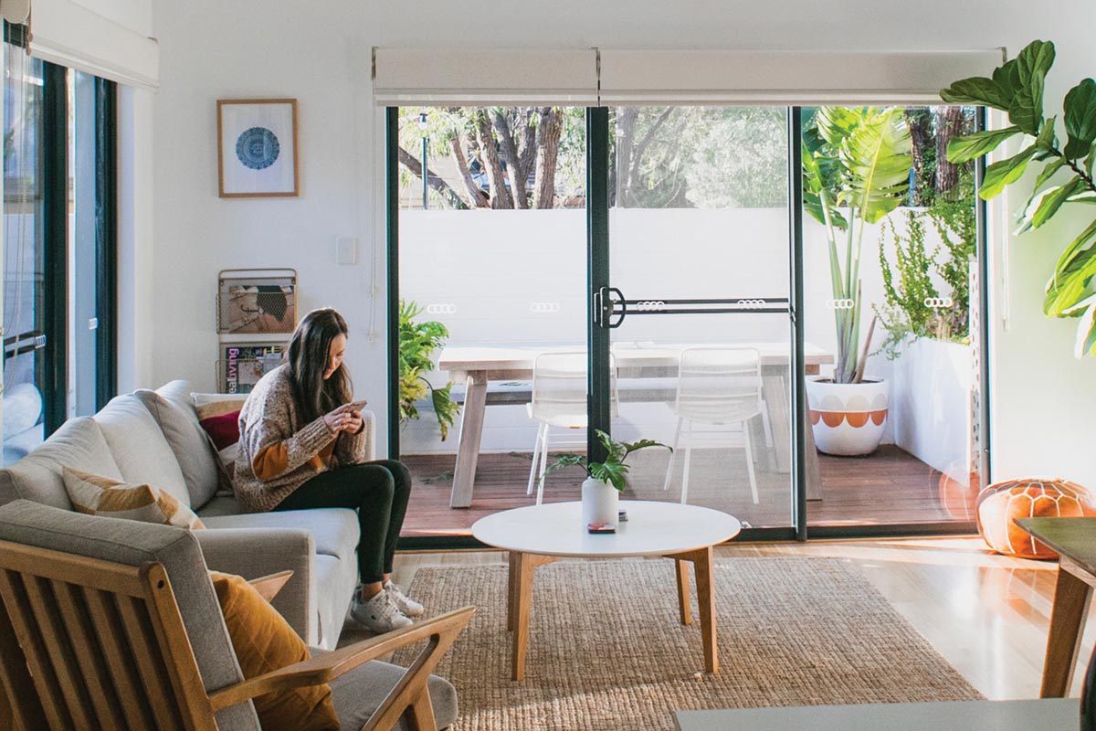 Woman on her phone, sitting in a home's living room