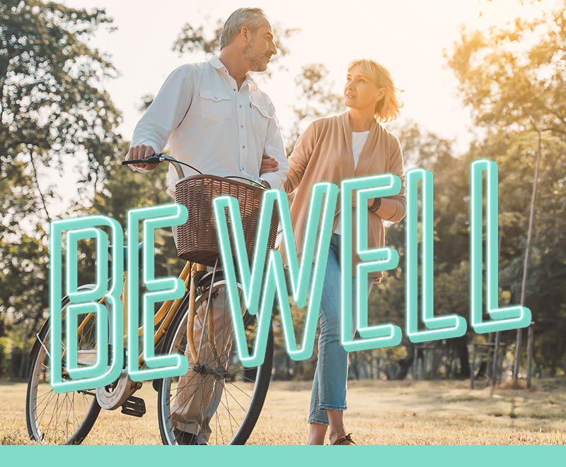 Department Image: BE WELL. Mature couple walking on trails.