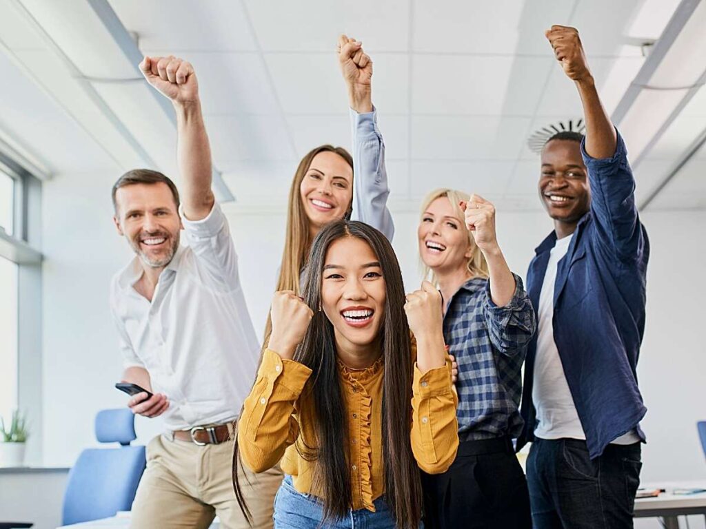 Coworkers cheering for article Workplaces Employees Love in Austin for newcomers relocating to Austin.