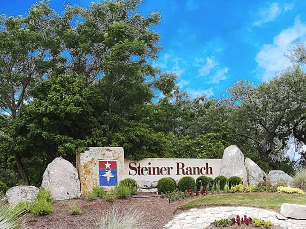 Front entrance of Steiner Ranch showing rocks with community name on them for article Neighborhood Spotlight: Steiner Ranch - : A Master-Planned Community in Austin, TX for newcomers moving to Austin.