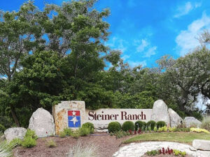 Front entrance of Steiner Ranch showing rocks with community name on them for article Neighborhood Spotlight: Steiner Ranch - : A Master-Planned Community in Austin, TX for newcomers moving to Austin.