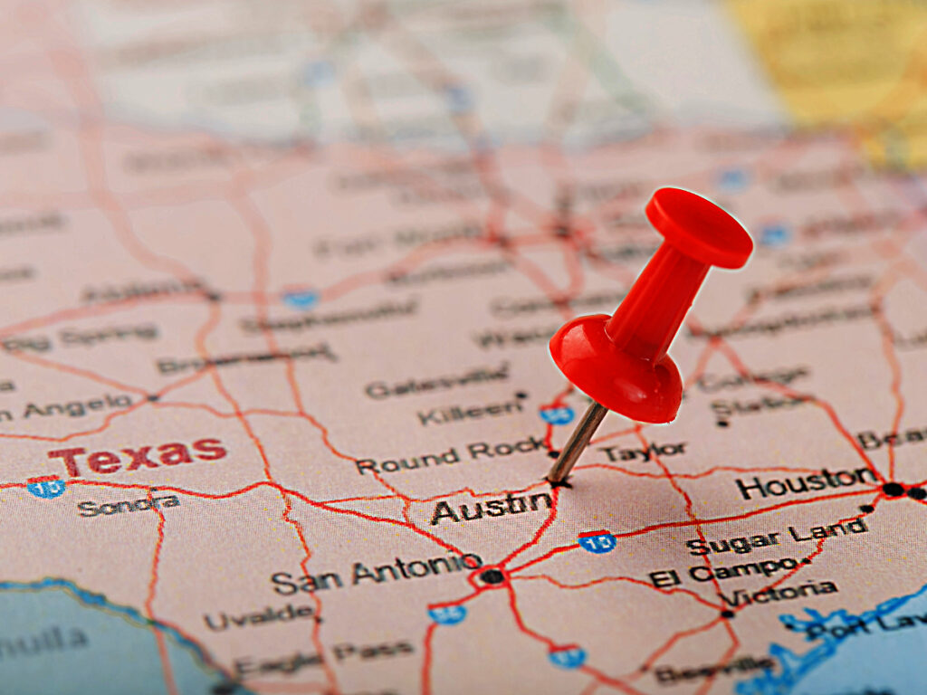 A map zoomed in on Texas with a red tack pinned on Austin for article Where is Austin, Texas? for newcomers moving to Austin.