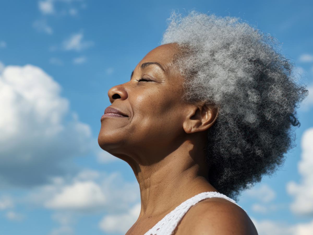 Side profile of woman's head and shoulder with her eyes closed facing toward the sky with a smile for article 15 Essential Resources for Women's Health in Austin for newcomers moving to Austin.