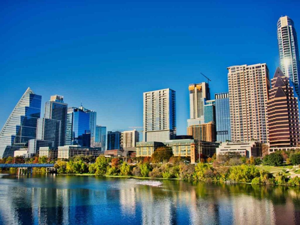 Downtown office buildings with lake in the foreground for article Austin Ranks #4 Among the Best Cities to Start a Career in 2025 for newcomers moving to Austin.
