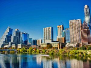 Downtown office buildings with lake in the foreground for article Austin Ranks #4 Among the Best Cities to Start a Career in 2025 for newcomers moving to Austin.