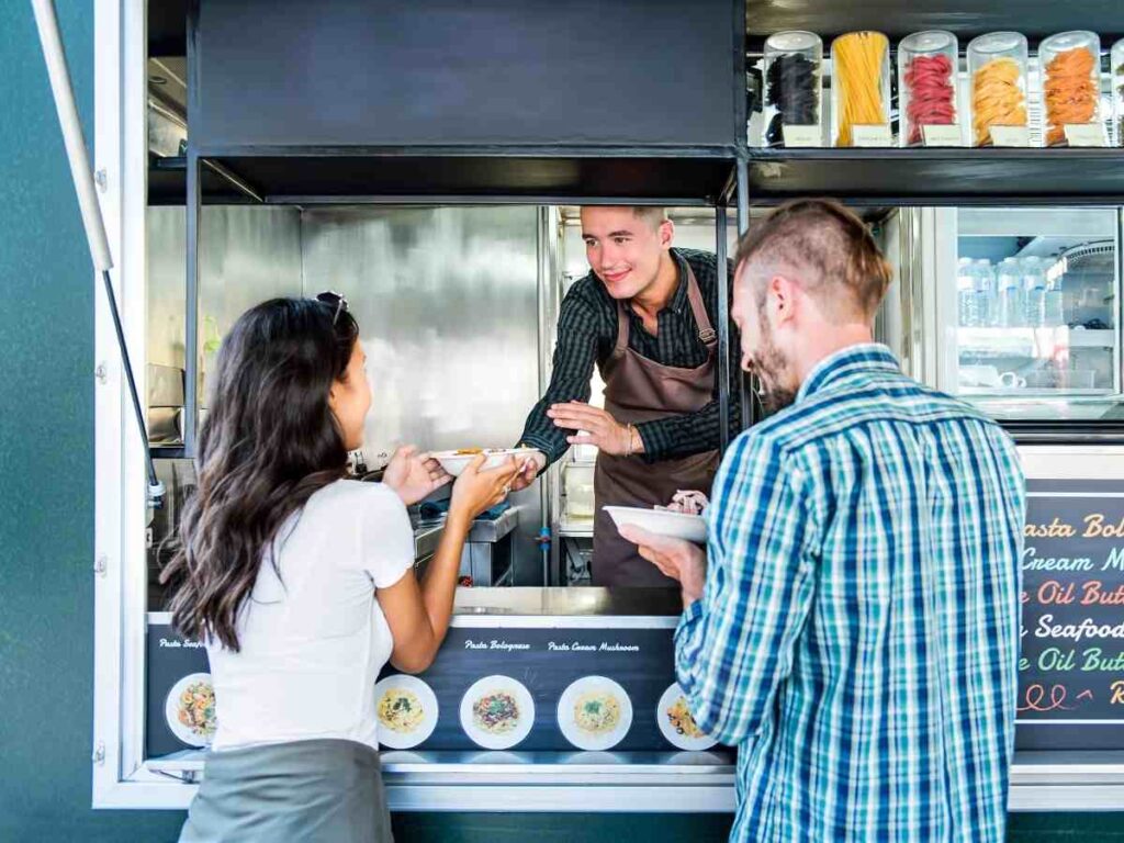 Couple getting food from a food truck window for article 15 Must-Try Austin Food Trucks for newcomers moving to Austin.