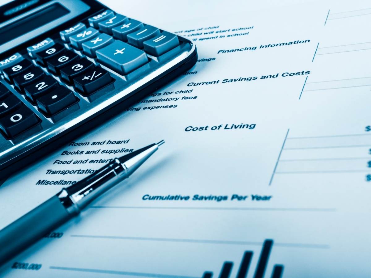 Calculator with pen on top of a piece of paper with cost of living budgeting numbers on it for article Cost of Living in Austin Compared to Other Major Cities for newcomers moving to Austin.