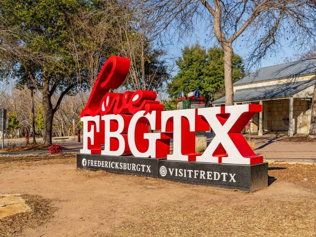 A large red and white sign that says love, FBGTX in Fredericksburg, Texas for article Best Day Trips and Weekend Getaways from Austin for newcomers moving to Austin area.