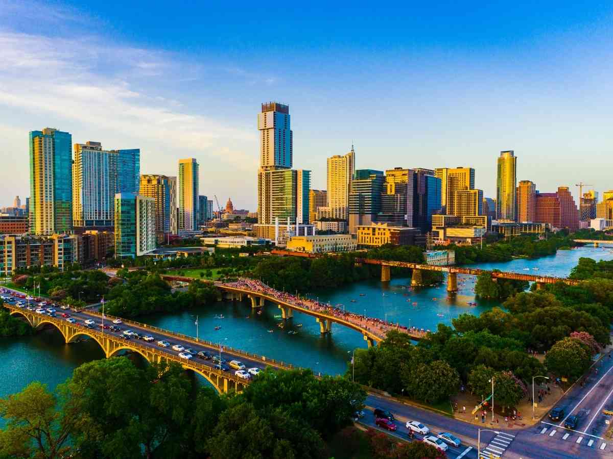 A bridge over a river with a city in the background for article Everything You Need to Know About Moving to Austin.